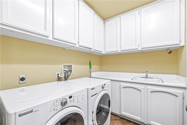 clothes washing area with a sink, washer and dryer, cabinet space, and dark tile patterned floors