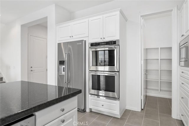 676 E Desert Willow Rd, Azusa, CA 91702 - kitchen featuring dark stone countertops, white cabinetry, appliances with stainless steel finishes, and light tile patterned flooring