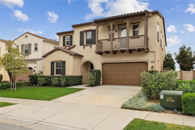 676 E Desert Willow Rd, Azusa, CA 91702 - mediterranean / spanish-style house featuring a balcony, concrete driveway, an attached garage, a front yard, and stucco siding