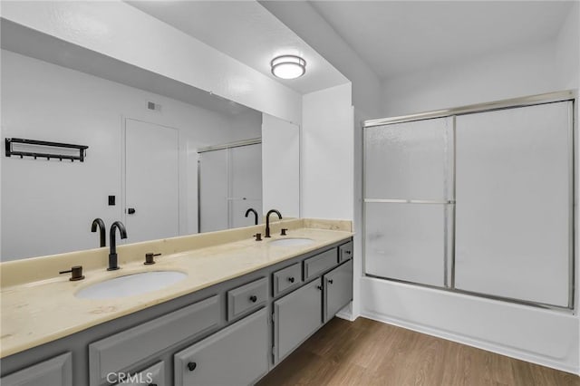 10201 Mason Ave Unit 115, Chatsworth, CA 91311 - bathroom featuring wood finished floors, double vanity, and enclosed tub / shower combo
