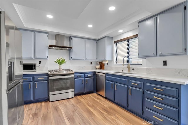 10201 Mason Ave Unit 115, Chatsworth, CA 91311 - kitchen with stainless steel appliances, wall chimney range hood, a sink, blue cabinets, and recessed lighting