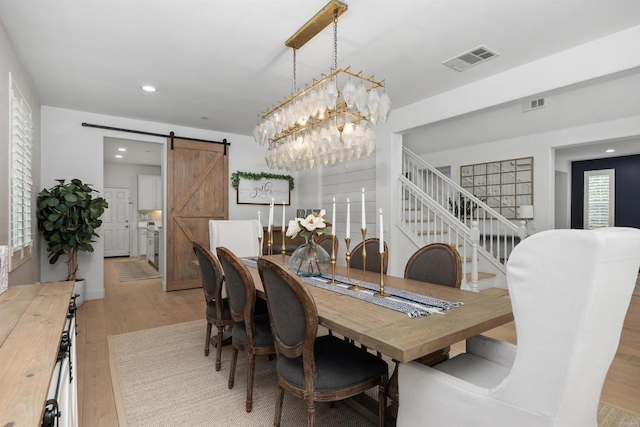 17236 Eagle Canyon Way, San Diego, CA 92127 - dining space with light wood-style flooring, a barn door, a chandelier, recessed lighting, and stairway