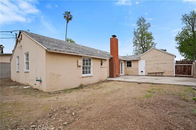 6701 Matilija Ave, Van Nuys, CA 91405 - rear view of house featuring a chimney, a patio, fence, and stucco siding
