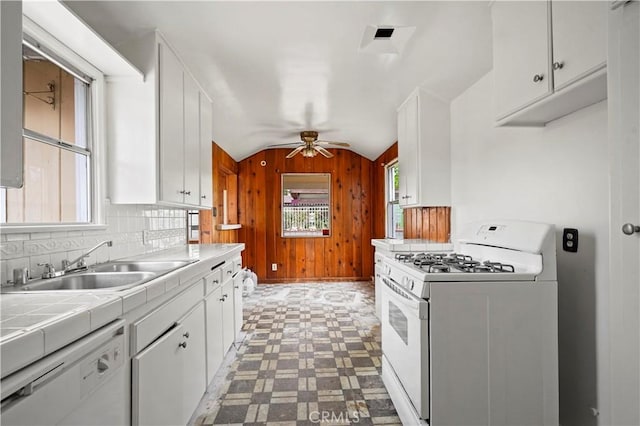 6701 Matilija Ave, Van Nuys, CA 91405 - kitchen with white appliances, light floors, tile countertops, a sink, and wooden walls
