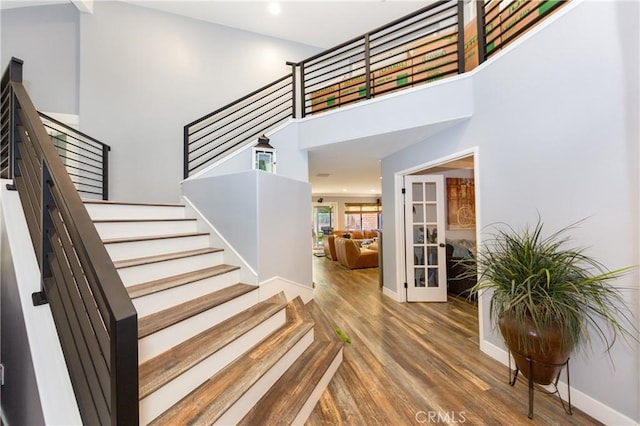 23015 Edenton Pl, Valencia, CA 91354 - stairs featuring baseboards, french doors, wood finished floors, and a high ceiling