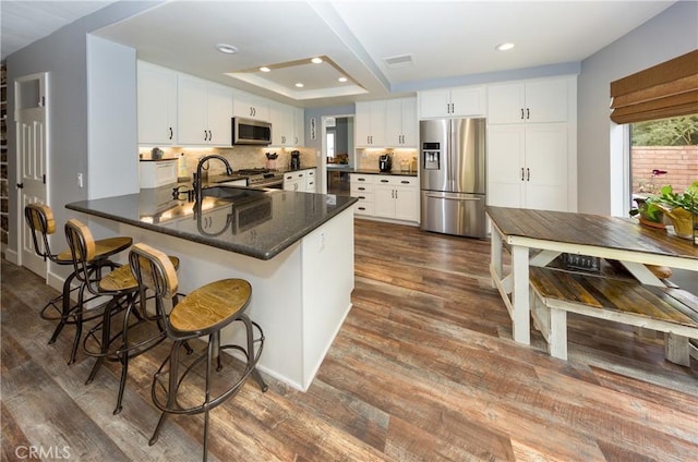 23015 Edenton Pl, Valencia, CA 91354 - kitchen with a sink, white cabinetry, a peninsula, appliances with stainless steel finishes, and dark wood-type flooring