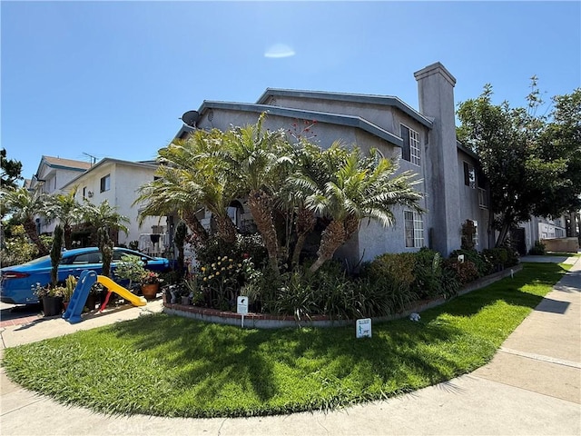 3702 W 126th St, Hawthorne, CA 90250 - view of property exterior with stucco siding, a chimney, and a lawn