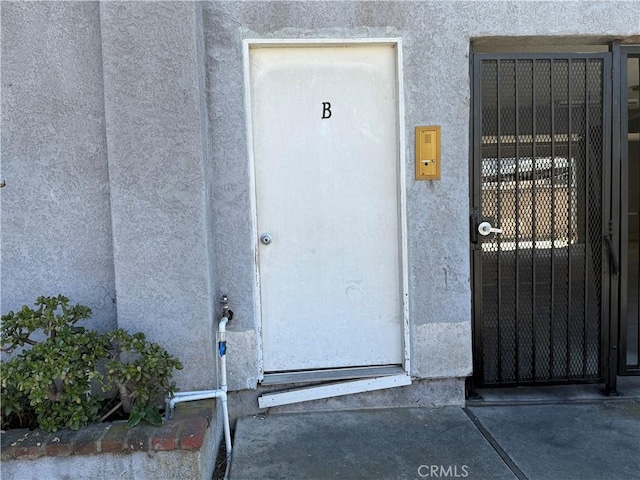 property entrance with stucco siding