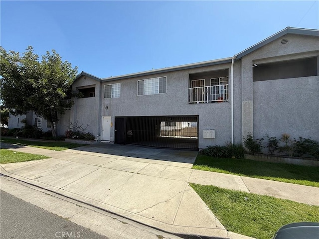 view of front of home featuring stucco siding, driveway, and a garage