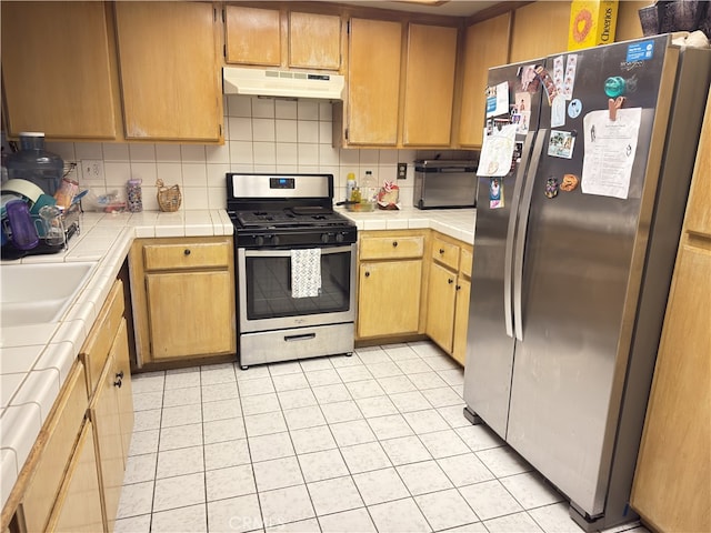 3702 W 126th St, Hawthorne, CA 90250 - kitchen with under cabinet range hood, tile counters, light tile patterned floors, and appliances with stainless steel finishes