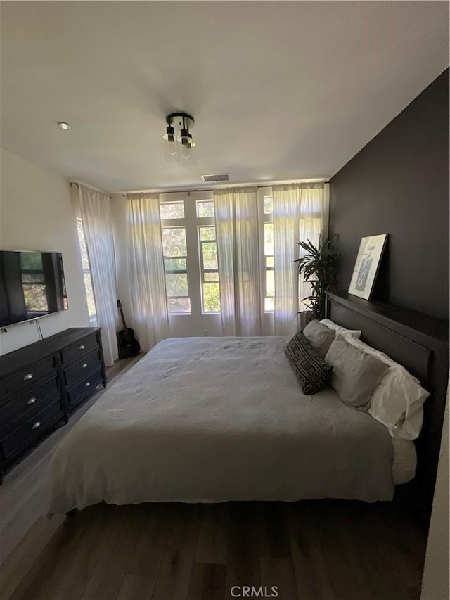 bedroom featuring wood finished floors and visible vents