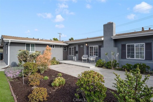 653 Joann St, Costa Mesa, CA 92627 - rear view of house with a chimney, a patio area, and stucco siding