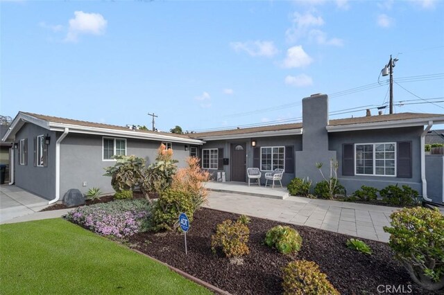 653 Joann St, Costa Mesa, CA 92627 - rear view of property featuring a patio, stucco siding, and a chimney