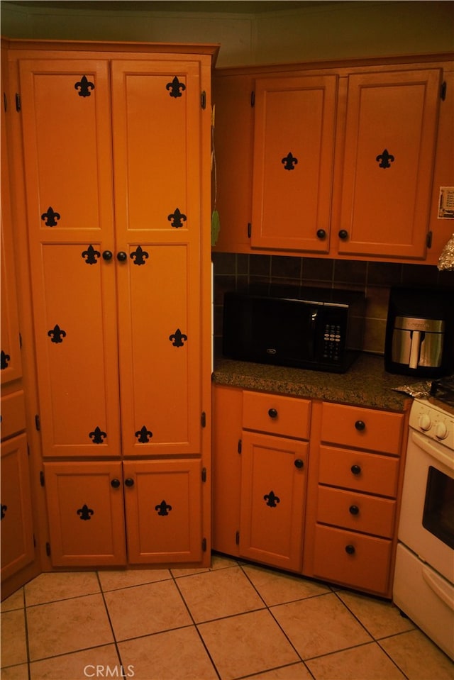kitchen with light tile patterned flooring, tasteful backsplash, black microwave, and white range
