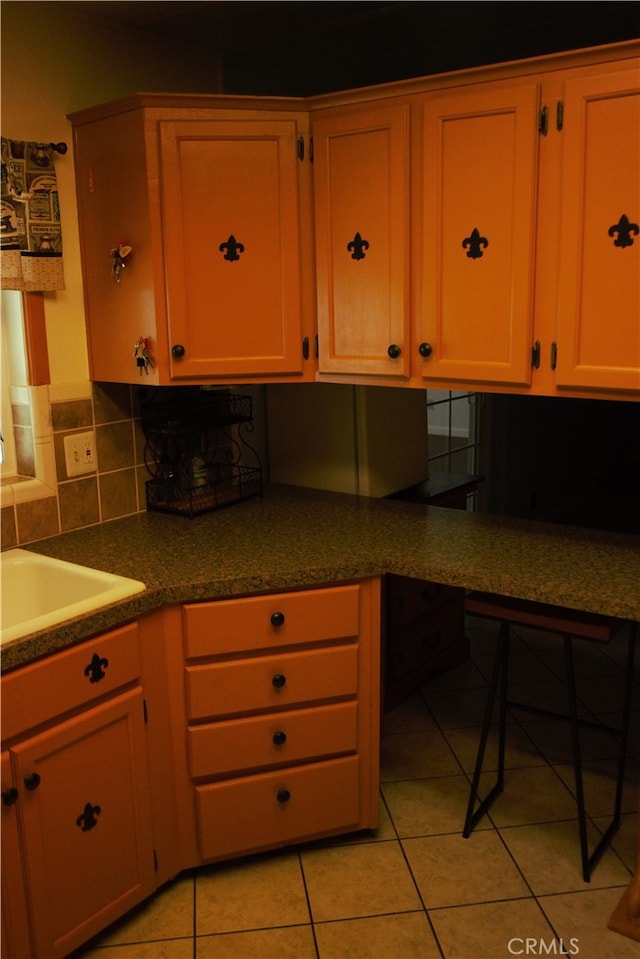 kitchen featuring built in desk, a sink, and light tile patterned floors