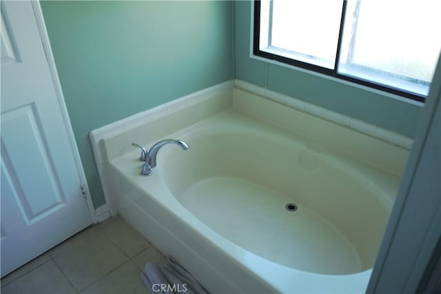 full bath featuring a garden tub and tile patterned flooring