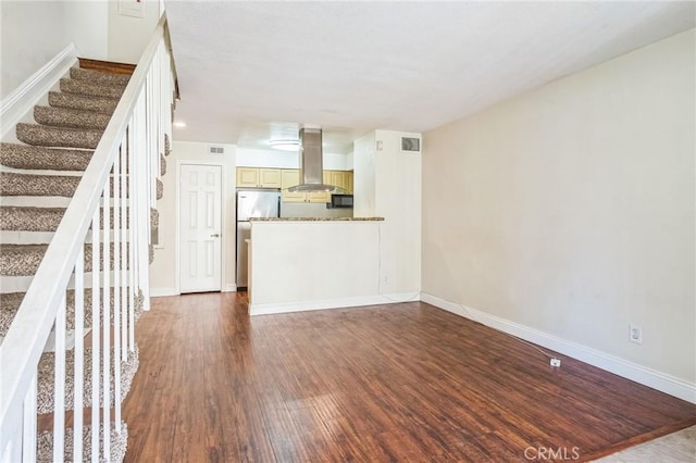 unfurnished living room with dark wood finished floors, stairway, visible vents, and baseboards