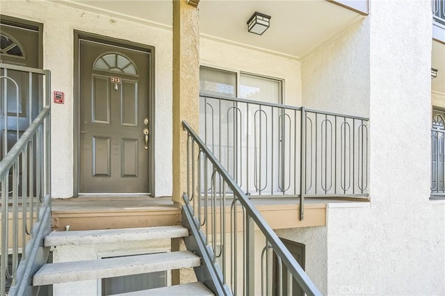 doorway to property featuring stucco siding and a porch