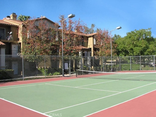 view of tennis court with fence and community basketball court