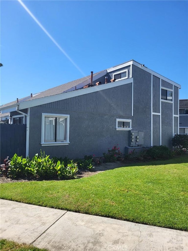 601 S Newhope St Unit 5, Santa Ana, CA 92704 - view of home's exterior featuring fence, a lawn, and stucco siding