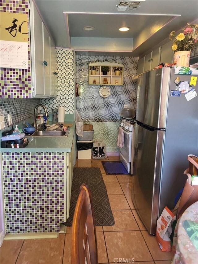 601 S Newhope St Unit 5, Santa Ana, CA 92704 - kitchen with freestanding refrigerator, light tile patterned floors, a raised ceiling, and a sink