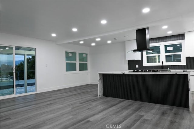 kitchen with a center island, recessed lighting, wood finished floors, and white cabinets