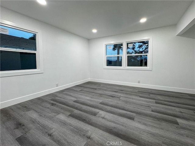 empty room featuring baseboards, recessed lighting, and wood finished floors