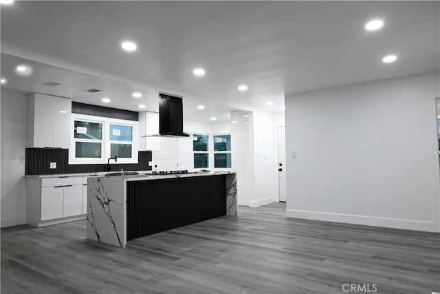kitchen featuring white cabinets, wood finished floors, island exhaust hood, a kitchen island, and modern cabinets
