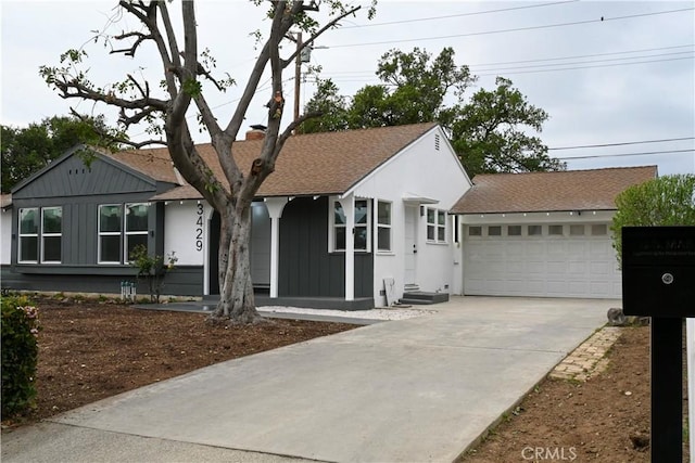ranch-style house with a shingled roof, board and batten siding, an attached garage, and concrete driveway