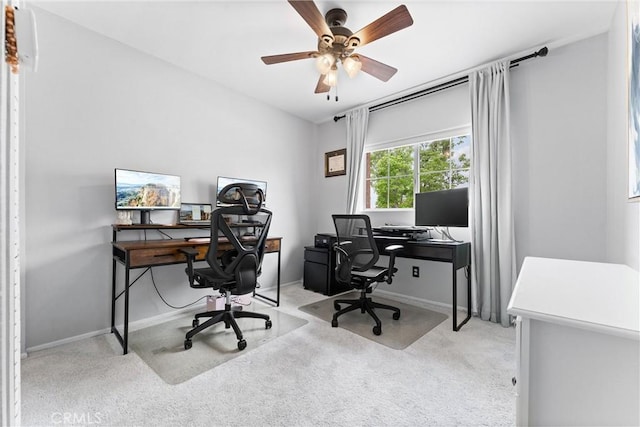 carpeted office featuring a ceiling fan and baseboards