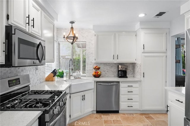 kitchen with a notable chandelier, white cabinets, appliances with stainless steel finishes, and a sink