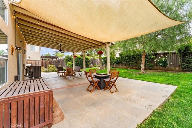 view of patio featuring a fire pit, ceiling fan, cooling unit, and a fenced backyard