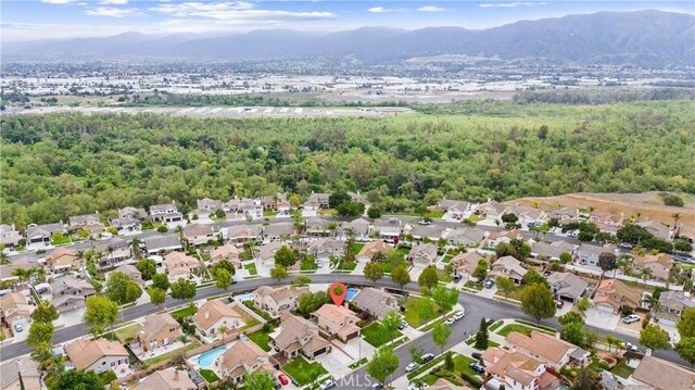 bird's eye view with a mountain view, a view of trees, and a residential view