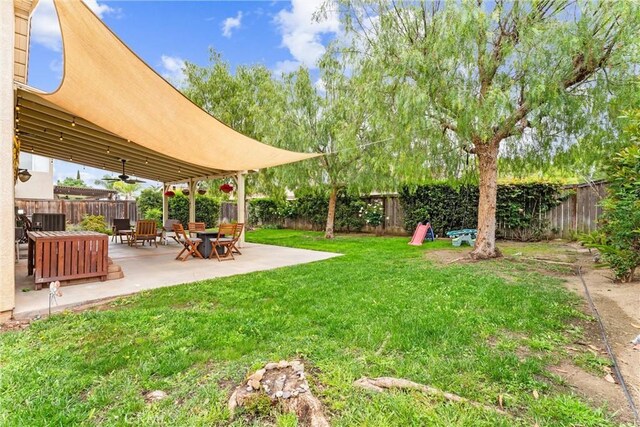 view of yard featuring a fenced backyard, a ceiling fan, and a patio