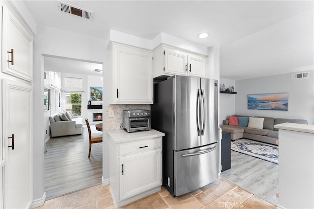 kitchen featuring freestanding refrigerator, visible vents, and open floor plan
