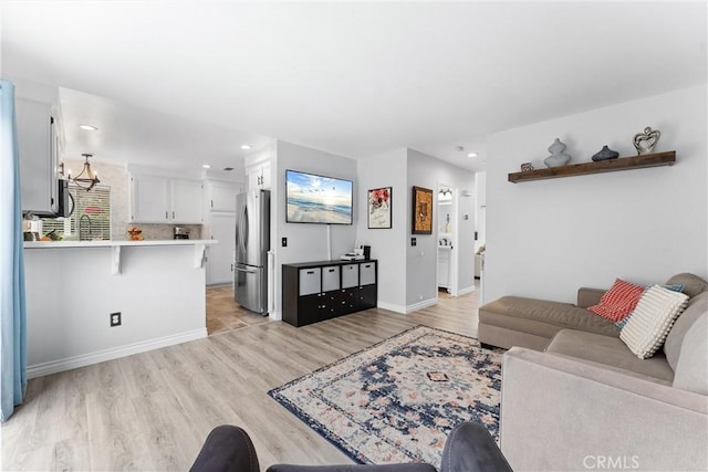 living area featuring recessed lighting, light wood-style floors, and baseboards
