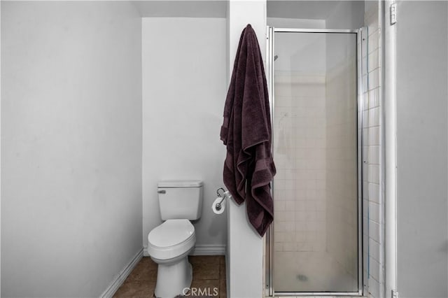 full bath with a shower stall, baseboards, toilet, and tile patterned flooring
