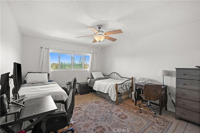 bedroom featuring a ceiling fan and a textured ceiling