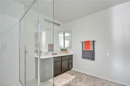 5374 Mission Rock Way, Jurupa Valley, CA 92509 - bathroom with double vanity, a shower stall, and baseboards