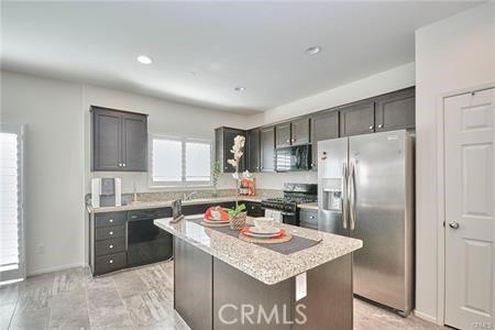 5374 Mission Rock Way, Jurupa Valley, CA 92509 - kitchen with stainless steel appliances, a center island, baseboards, and recessed lighting