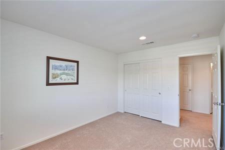 5374 Mission Rock Way, Jurupa Valley, CA 92509 - unfurnished bedroom featuring a closet, baseboards, and light carpet