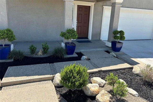 5374 Mission Rock Way, Jurupa Valley, CA 92509 - doorway to property featuring stucco siding, concrete driveway, and a garage