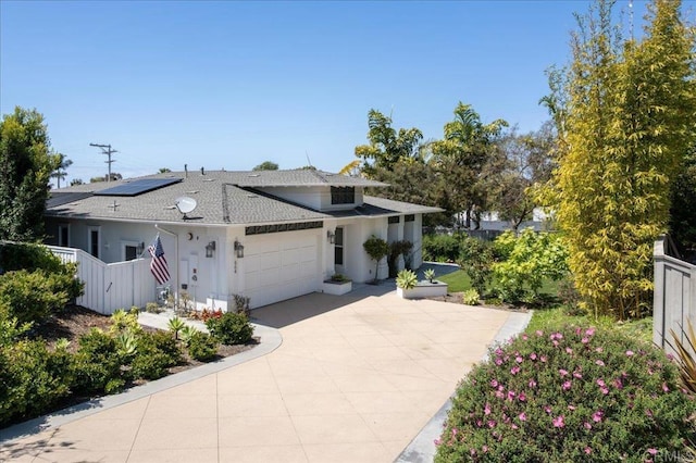 view of front of home with driveway, a shingled roof, an attached garage, fence, and stucco siding