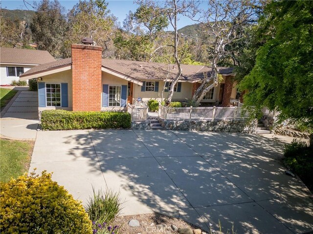 3192 Lytle Creek Rd, Lytle Creek, CA 92358 - view of front facade with stucco siding, a chimney, covered porch, and a mountain view
