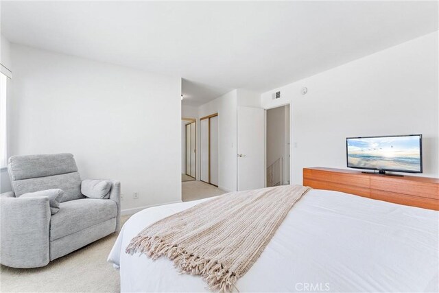 bedroom featuring visible vents and light carpet