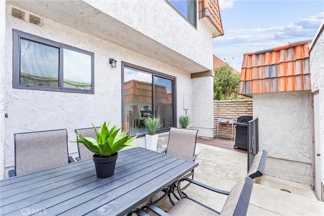 view of patio with outdoor dining space, visible vents, and grilling area