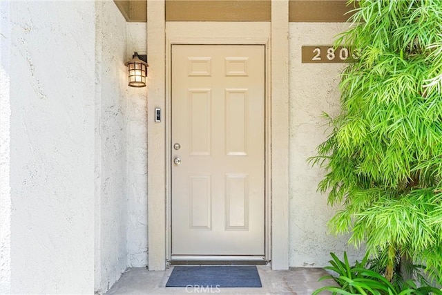 view of exterior entry featuring stucco siding