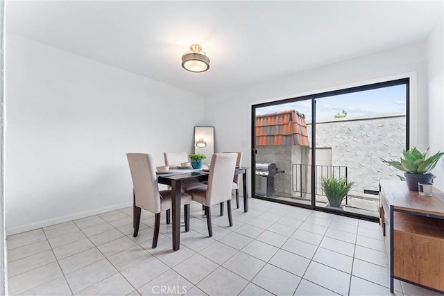 dining space featuring light tile patterned floors and baseboards