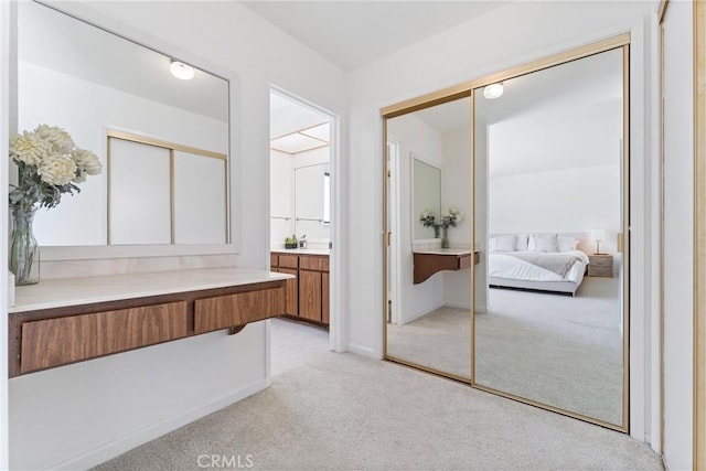 bathroom featuring vanity, ensuite bathroom, baseboards, and carpet floors