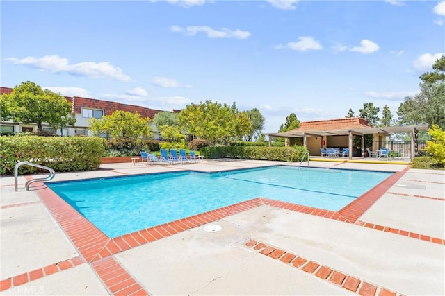 community pool featuring fence and a patio